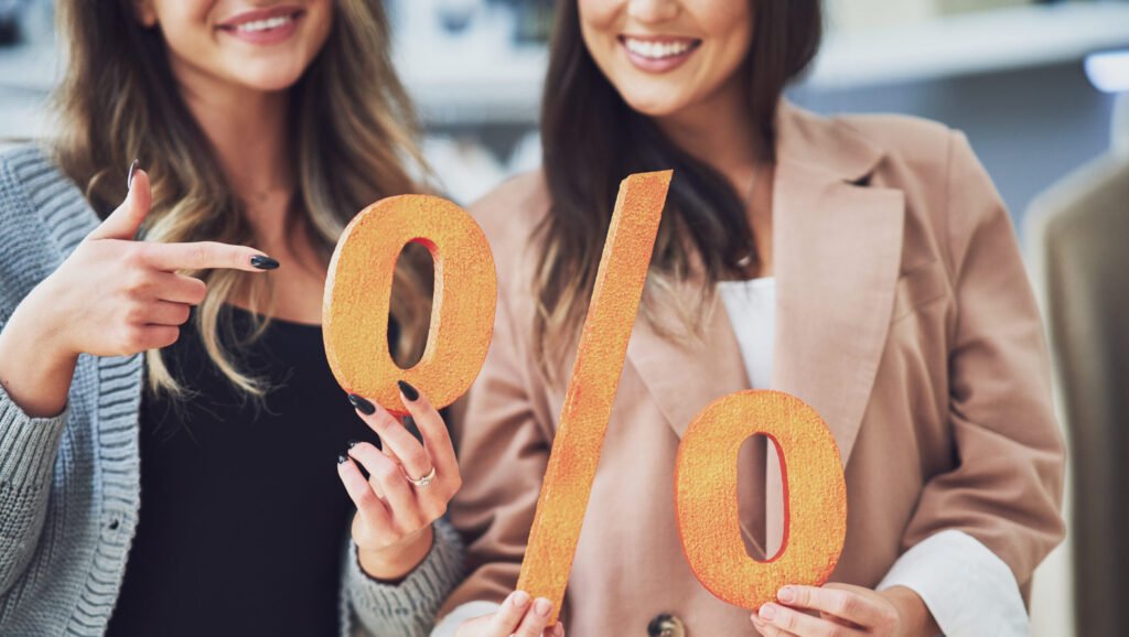 Two women holding a percentage sign, symbolizing Ontario mortgage rates August 2025. Contact Maurice at 416-618-9312 or maurice@mortgagemaurice.ca for guidance
