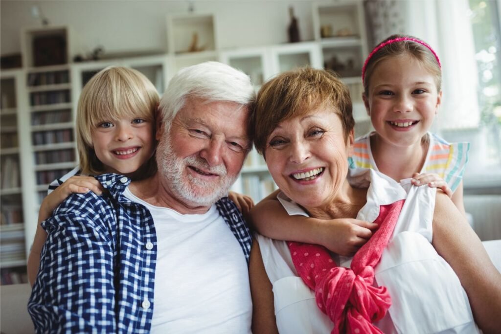 Grandparents relaxing at home with their two grandchildren